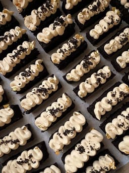 Piped chocolate eclairs with gold leaf