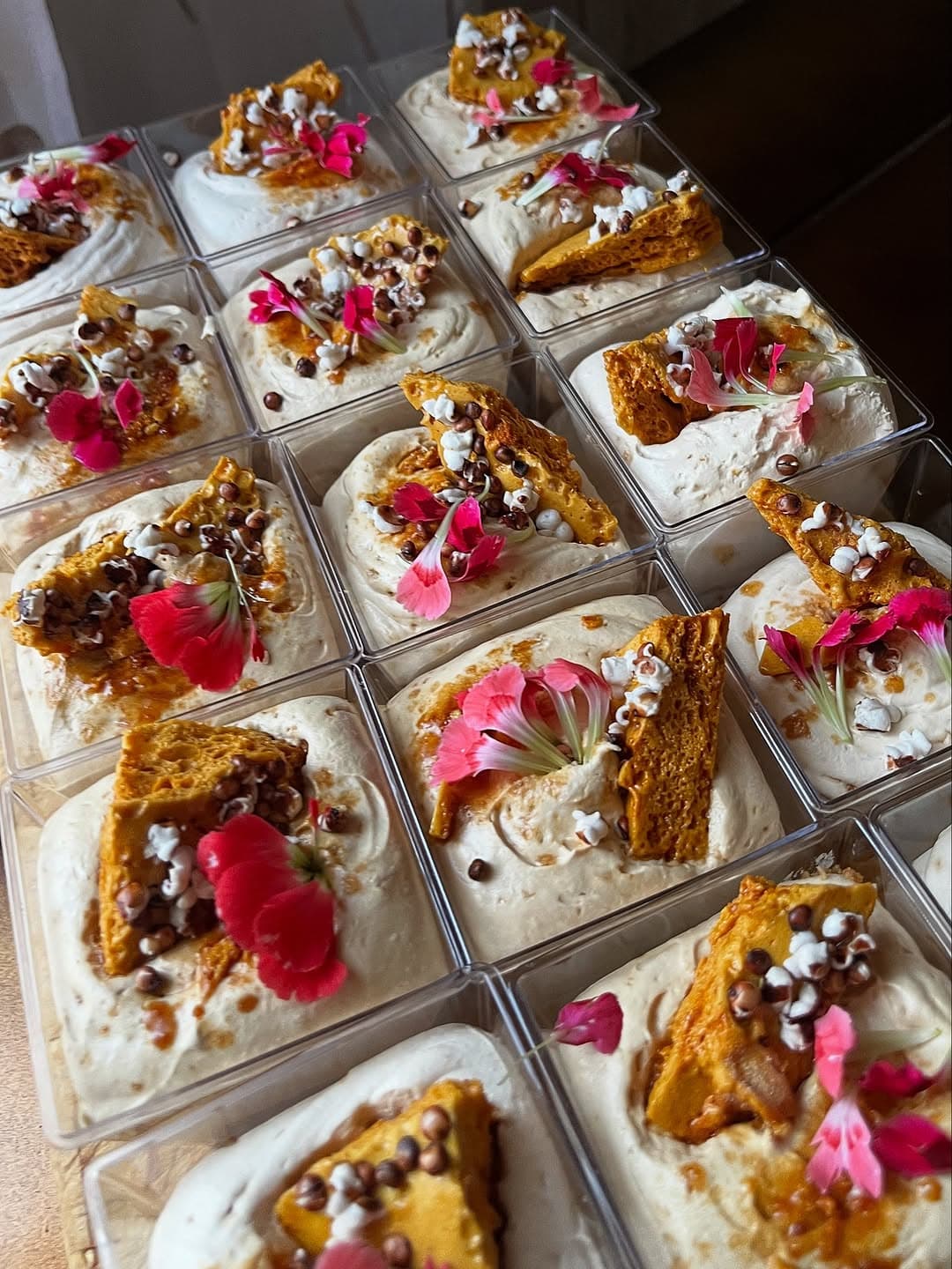 Rows of bespoke dessert boxes topped with honeycomb and edible flowers