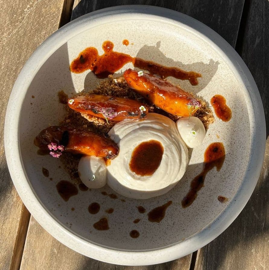 Chef-plated dessert with cream quenelle and brûléed fruit